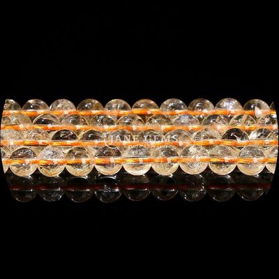 Des perles de pierre précieuse de forme ronde naturelle, du quartz clair, du citrine, de l'améthyste.