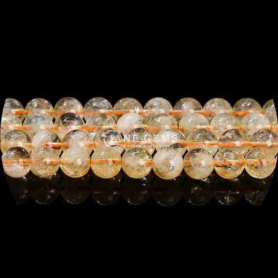 Des perles de pierre précieuse de forme ronde naturelle, du quartz clair, du citrine, de l'améthyste.