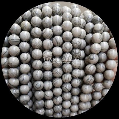 Des perles de pierre précieuse de forme ronde, des perles en bois, des brins de perles lâches pour des bracelets, des décorations faites à la main.